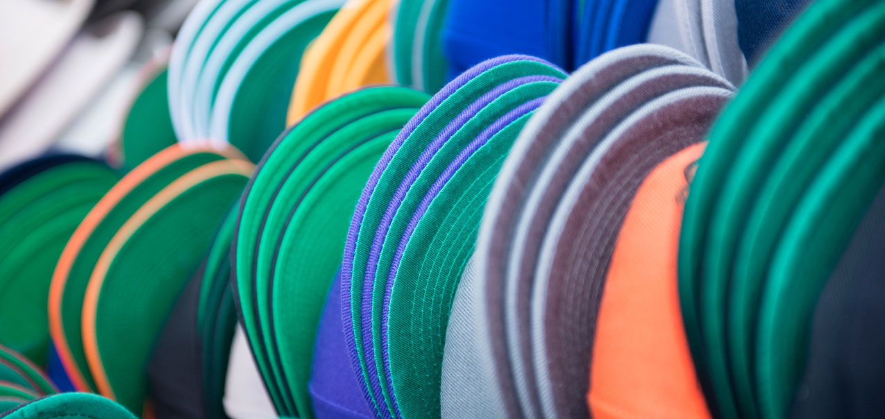 Image of several baseball hats stacked on top of one another.