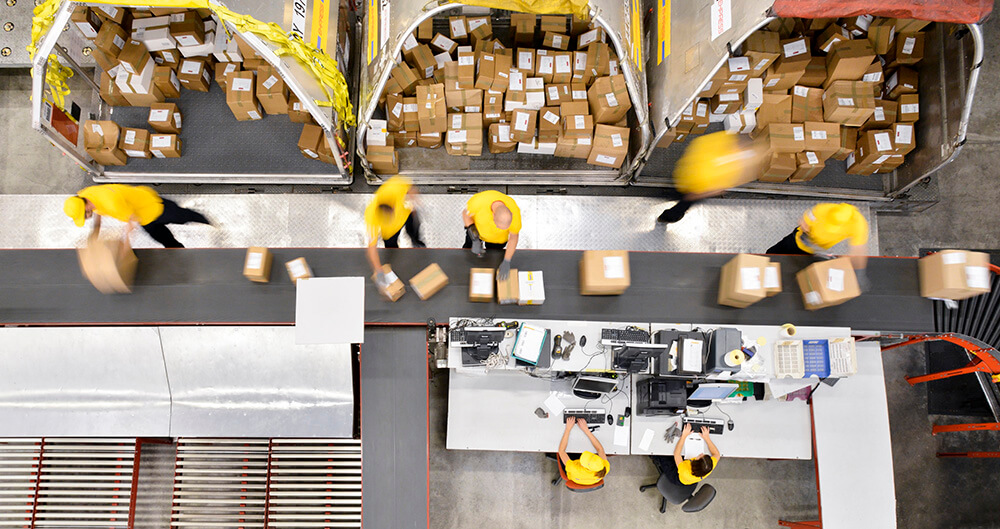 Overhead shot of warehouse workers in a shipping line.