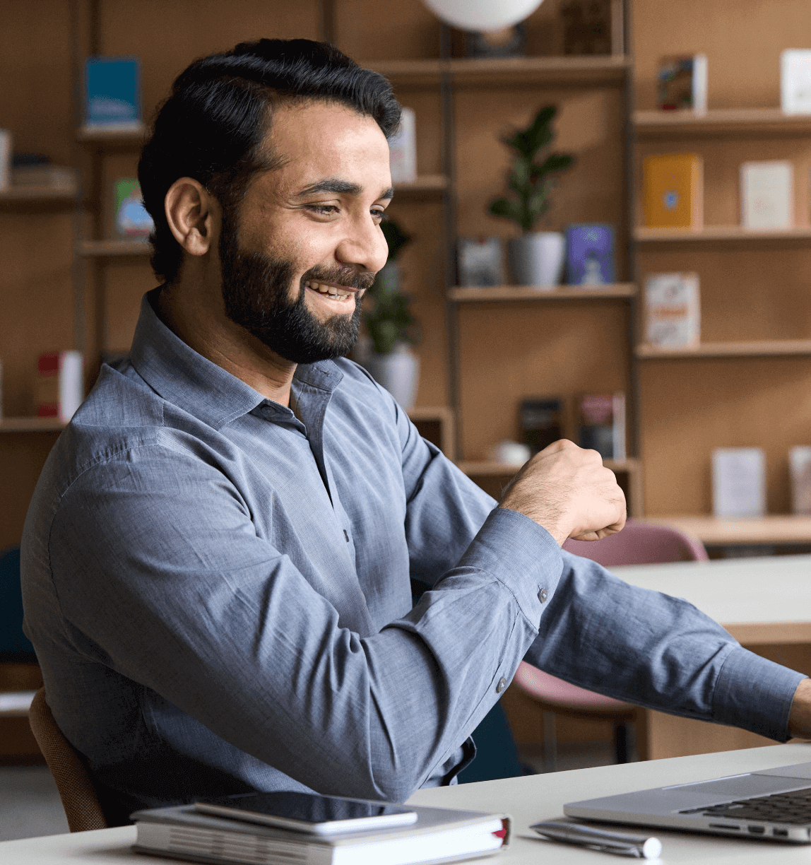 Man smiling and looking at laptop.